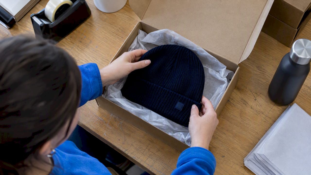 Branded beanie nestled in a tissue-lined gift box